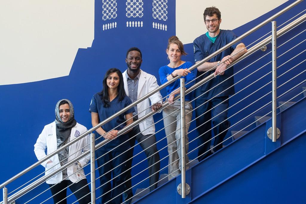 五名英国东北大学卫生专业的学生一起在楼梯上摆姿势