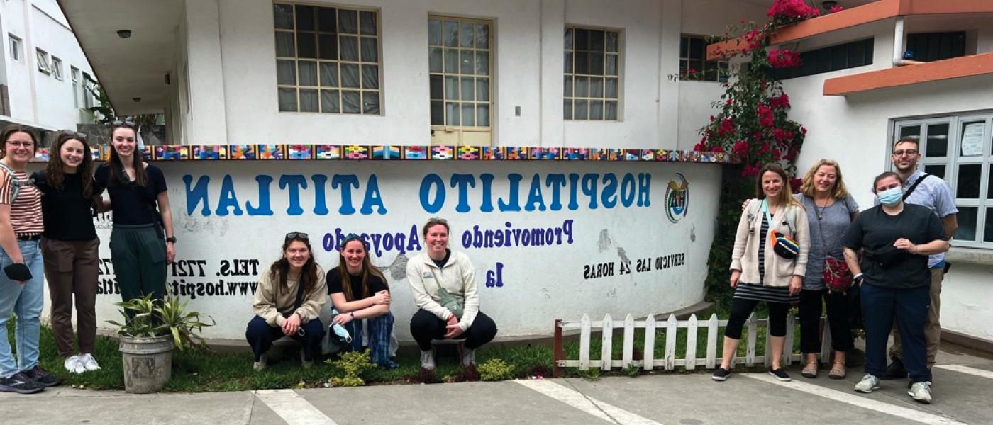 一群学生坐在危地马拉的一所医院大楼前